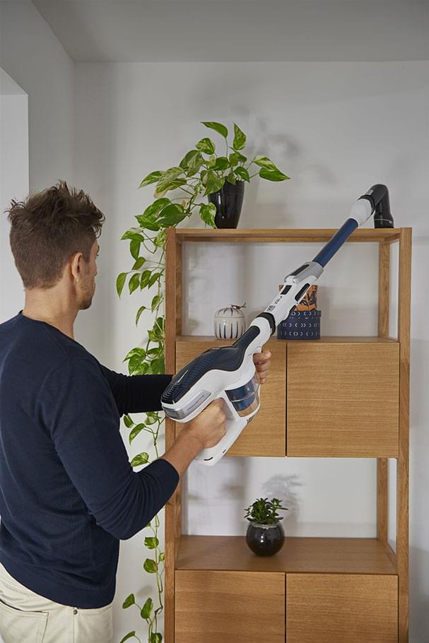 Hombre aspirando sobre un mueble